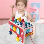 Toddler using wooden elephant pounding bench with hammer